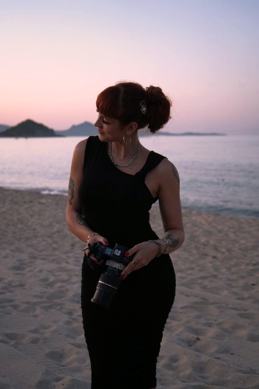 Ginevra Carrara con la sua macchina fotografica sulla spiaggia al crepuscolo